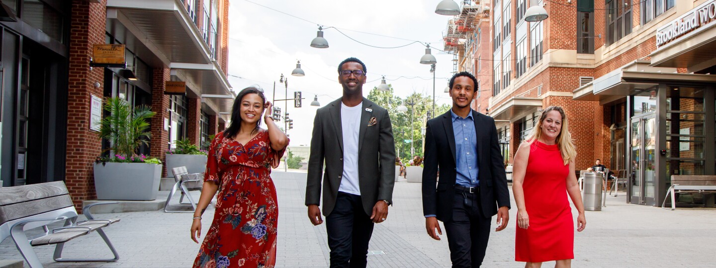 four successful professionals confidently walking down the street